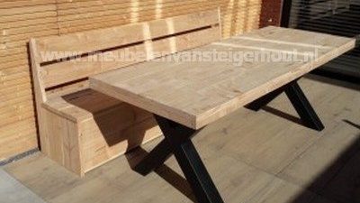 Tafel stalen kruispoot met klepbank douglas hout Houten bank en tafel met zwarte metalen poten, gelegen op een houten vloer.