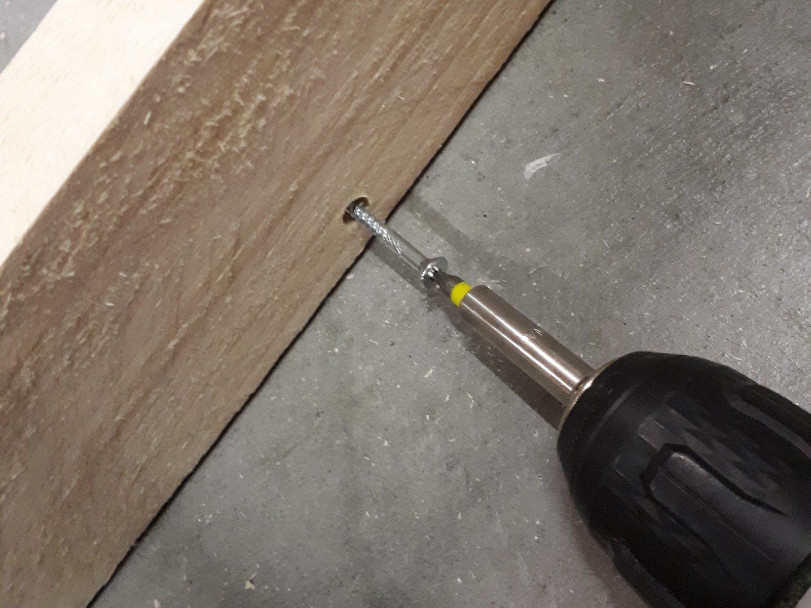 Bouwpakket steigerhout Schroef wordt vastgedraaid met een accuschroevendraaier in een houten plank