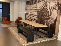 Tafel steigerhout ontvangstruimte bedrijf Moderne eetruimte met houten tafel, stoelen en een grote wandfoto.