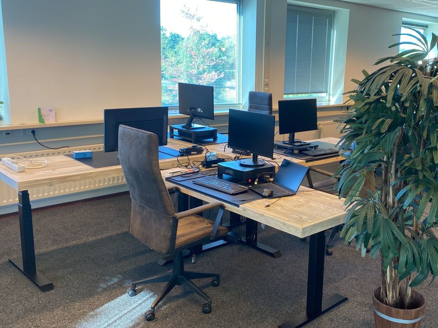 Elektrisch zit-sta bureau met steigerhouten blad Kantoor met meerdere steigerhouten zit-sta bureaus